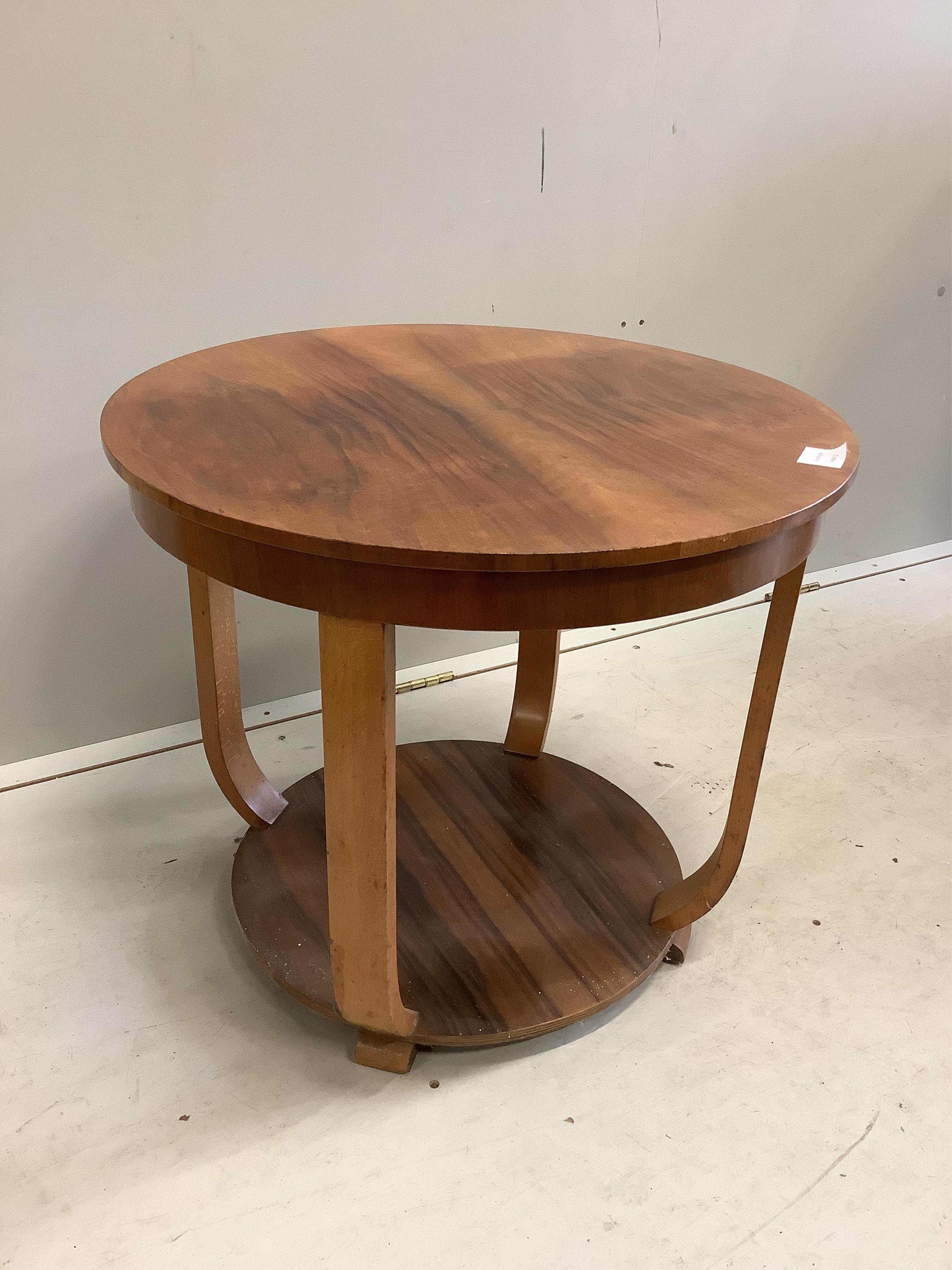 An Art Deco walnut circular two tier occasional table, diameter 60cm, height 52cm. Condition - fair